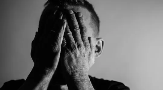 Man covering his eyes.