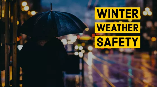 Image of a person under an umbrella looking out onto a rainy street. Text reads WINTER WEATHER SAFETY