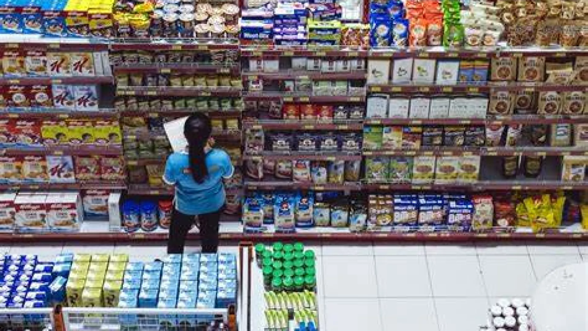 A photo of a person standing in front of grocery store shelves