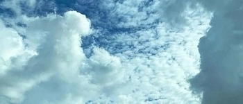 Image of clouds with blue sky beginning to peek through.