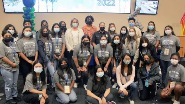 Young women campers shown at recent HERricane (spelled H-E-R) event in Los Angeles pose with FEMA Administrator, one of the main speakers.