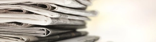 Photo image of a stack of newspapers.