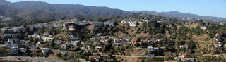 Photo of the Pacific Palisades, taken from the sky above the ocean and showing large homes on a terraced hillside.