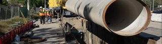 Image of a DWP crew beside an underground pipeline that is being lowered into the ground.