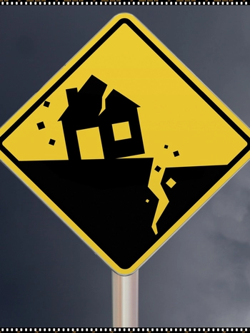 An image of a road signs showing fractured earth from a quake and a crrumbling house above it. 