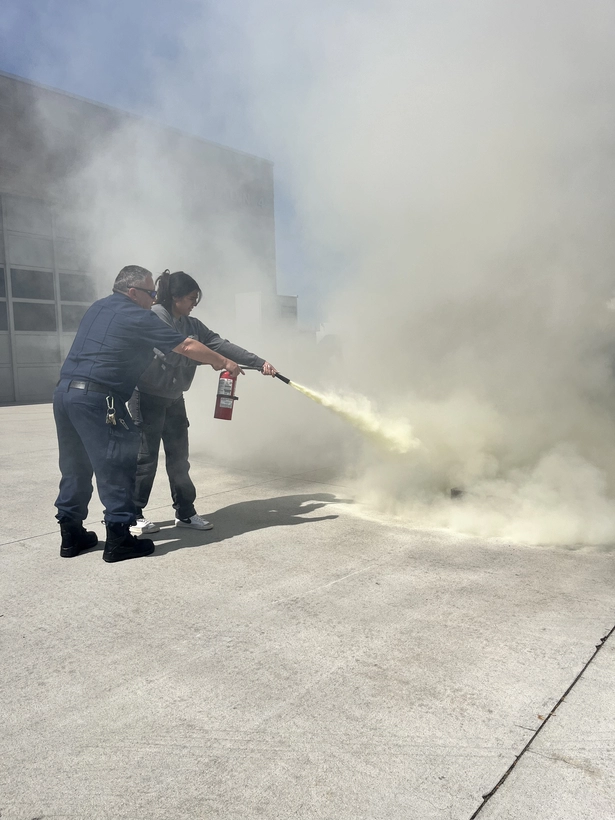 Camp ReadyLA participant using a fire extinguisher during a demonstration. 